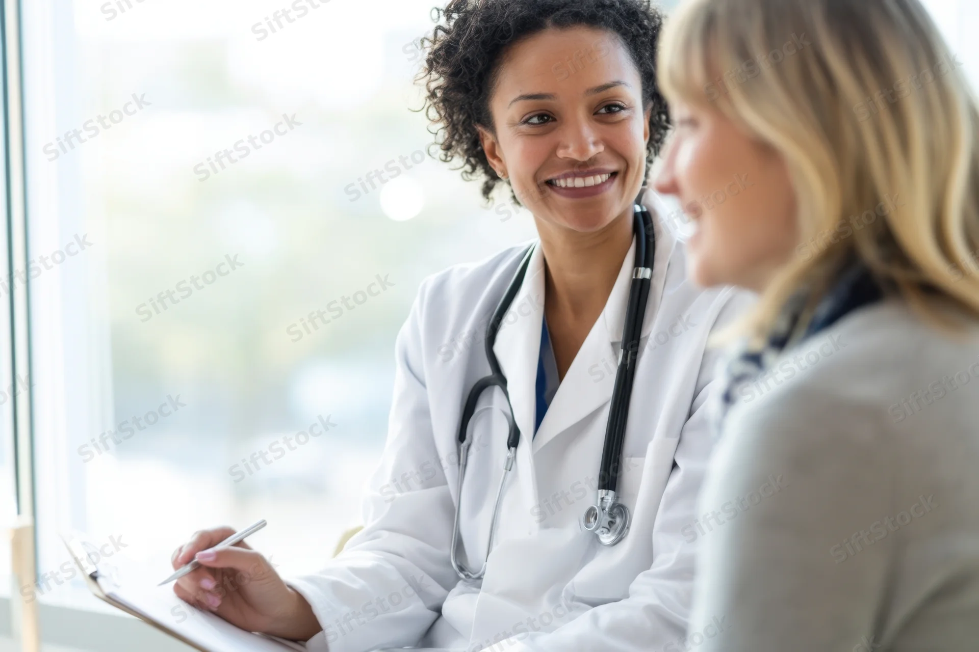 Female doctor smiling while consulting with a patient in a clinic office