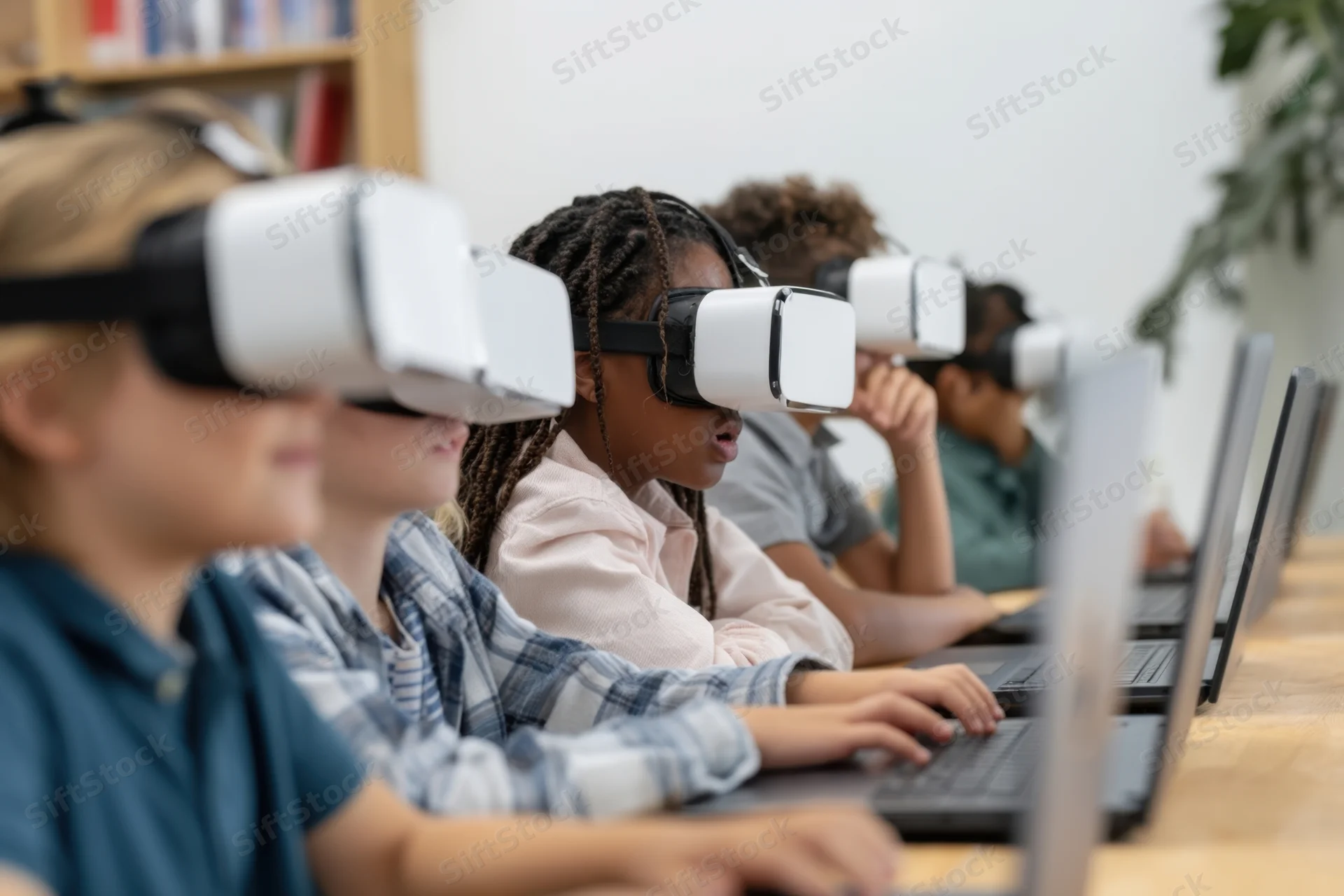Children wearing vr headsets and using laptops in a classroom setting