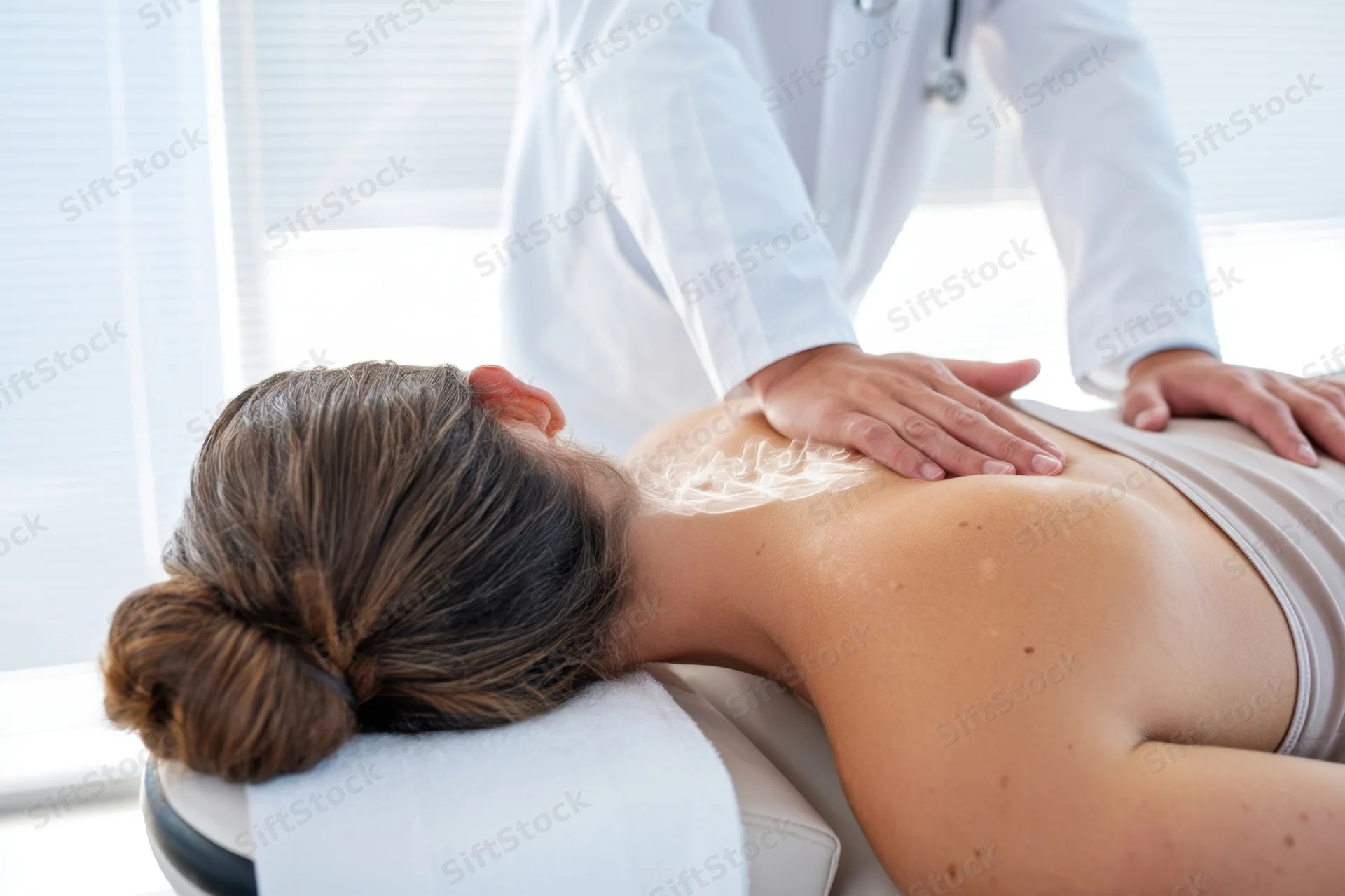 Woman receiving spinal therapy on treatment table in clinic