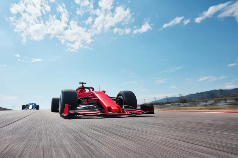 Red formula1 car racing on track from low close angle