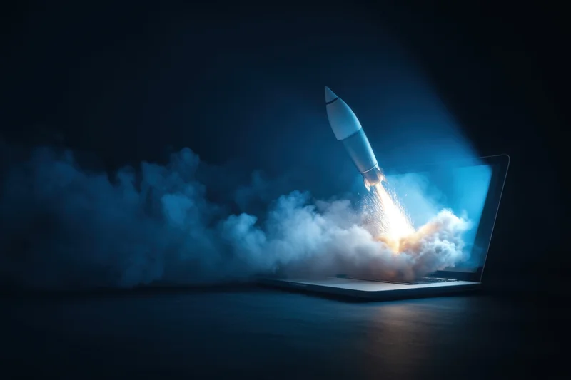 Rocket launching from laptop screen into dark space with smoke and light trail