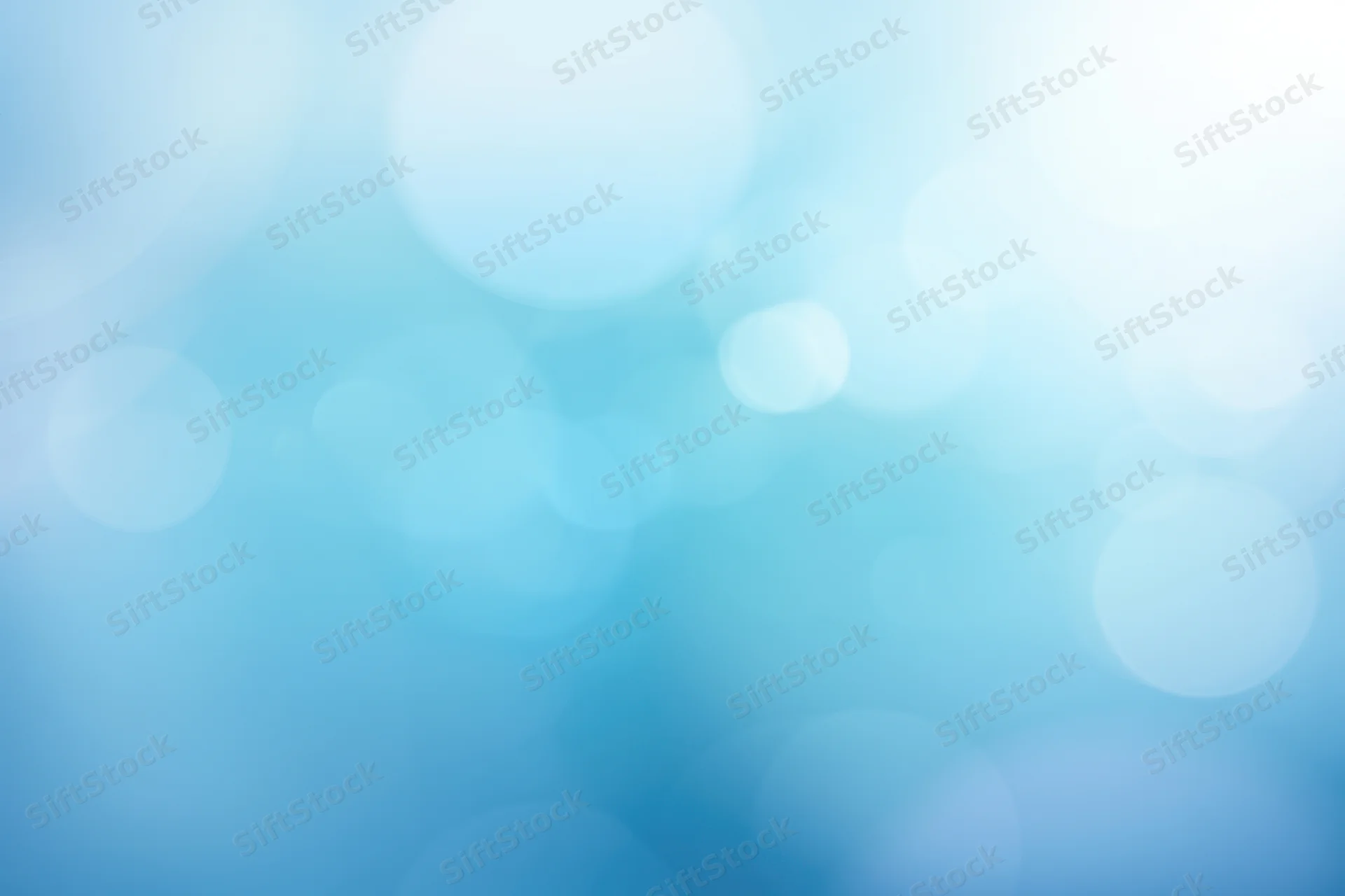 Soft blue abstract gradient with bokeh light effects as background