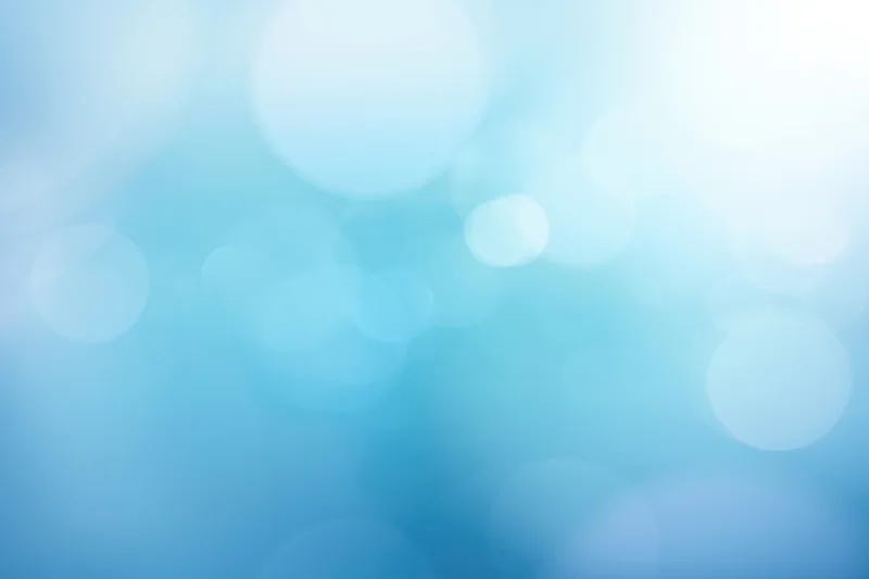 Soft blue abstract gradient with bokeh light effects as background