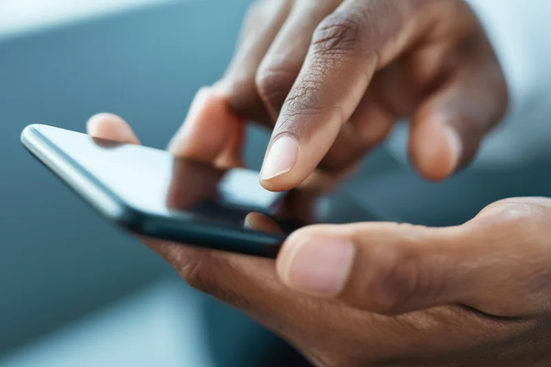 Close-up of hands holding a smartphone with finger poised to tap the screen