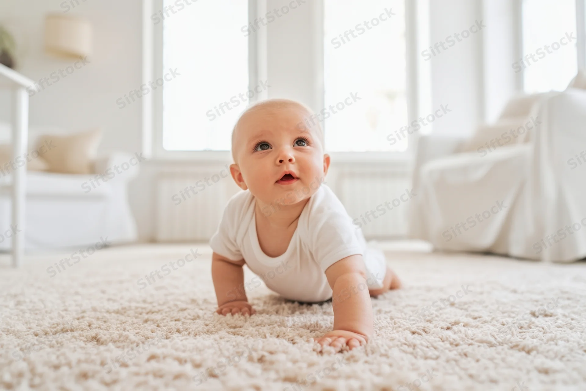 Baby crawling on beige carpet in bright living room