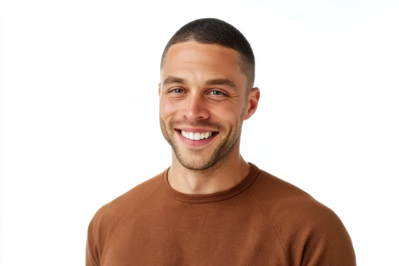 Smiling man in brown sweater posing against white background