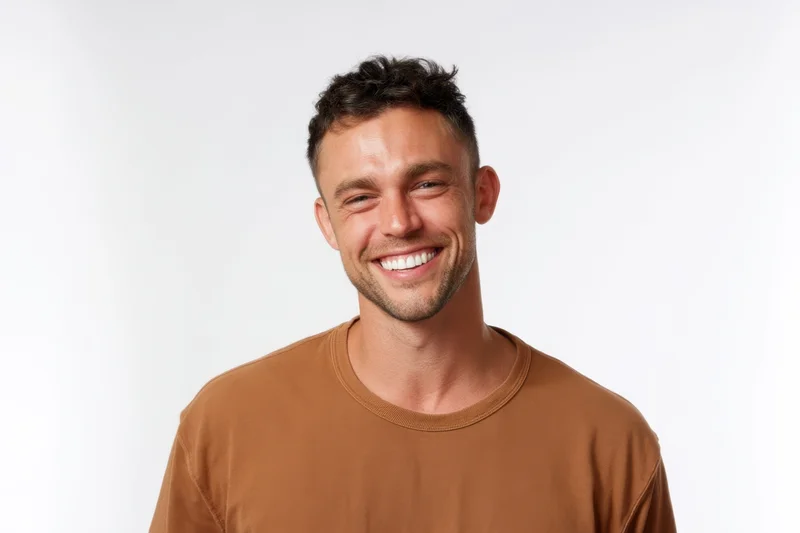 Smiling man in brown tshirt posing against white background