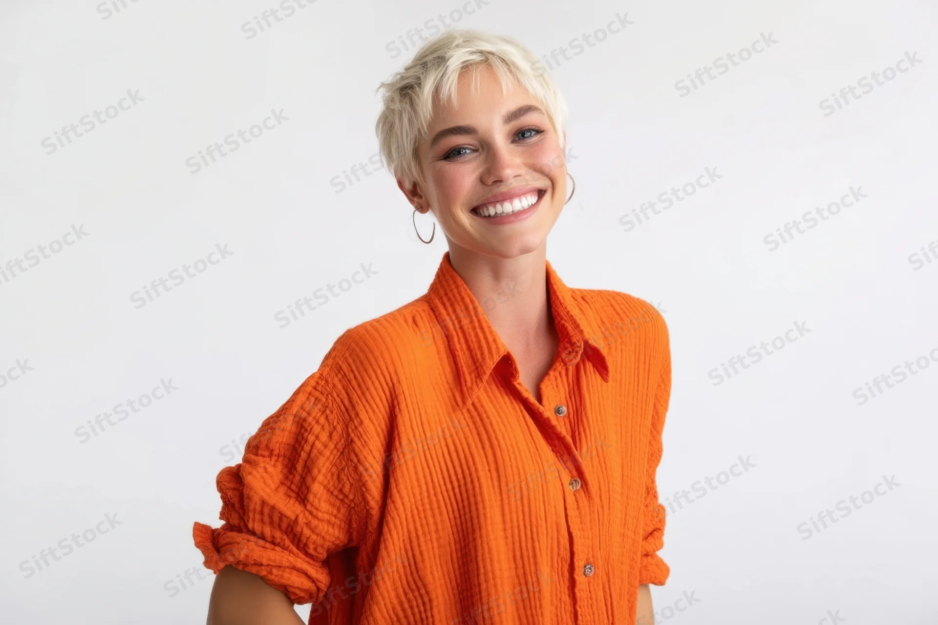 Smiling woman with short platinum-blonde hair wearing an orange ribbed shirt in a studio setting