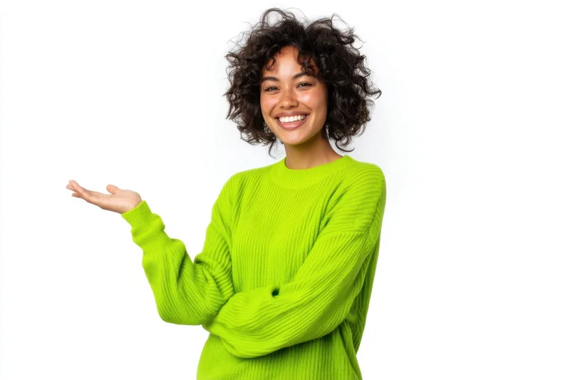 Smiling woman with curly dark hair in lime green sweater gesturing with open hand against white background