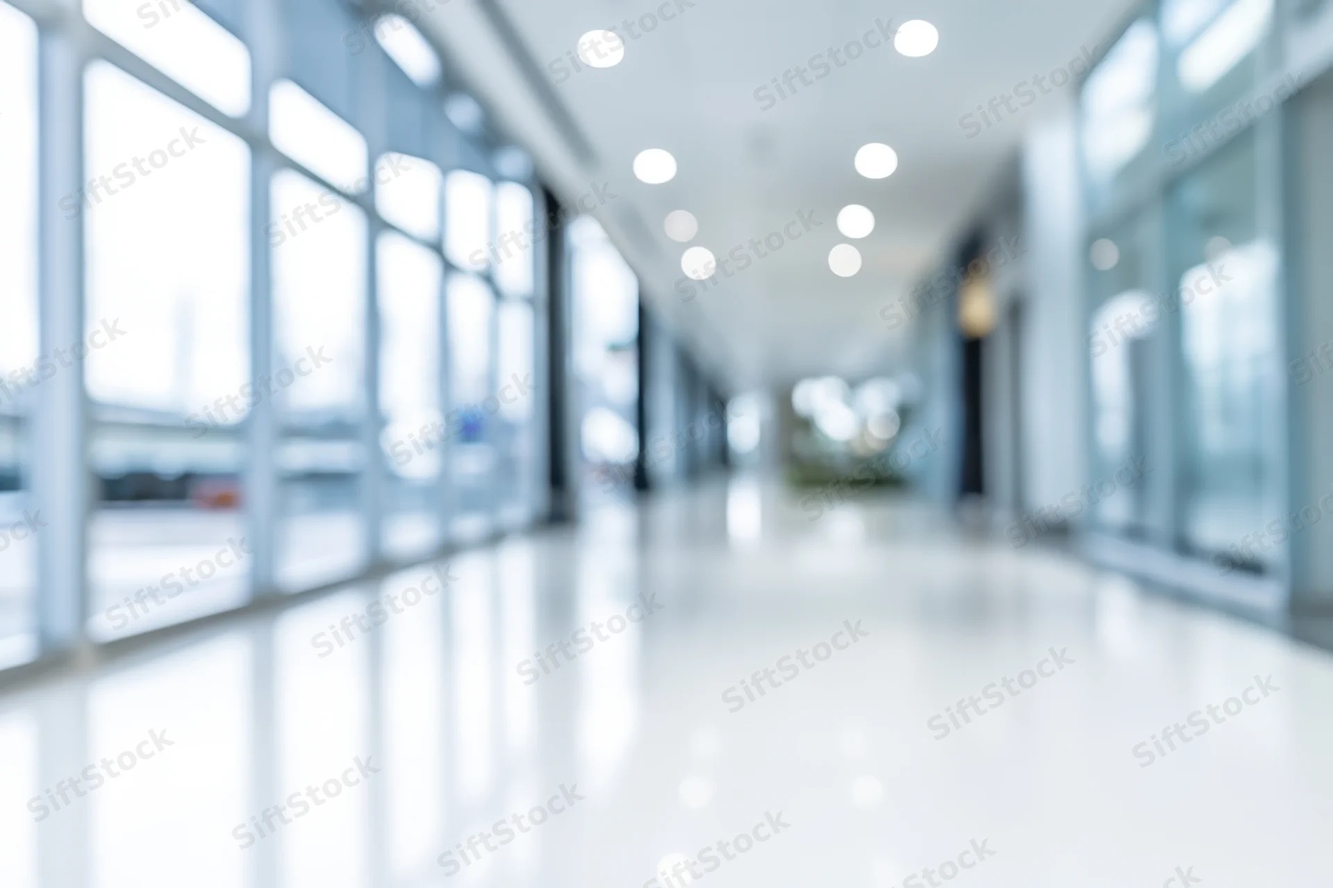 Bright empty modern lobby with floor-to-ceiling windows and polished white floor