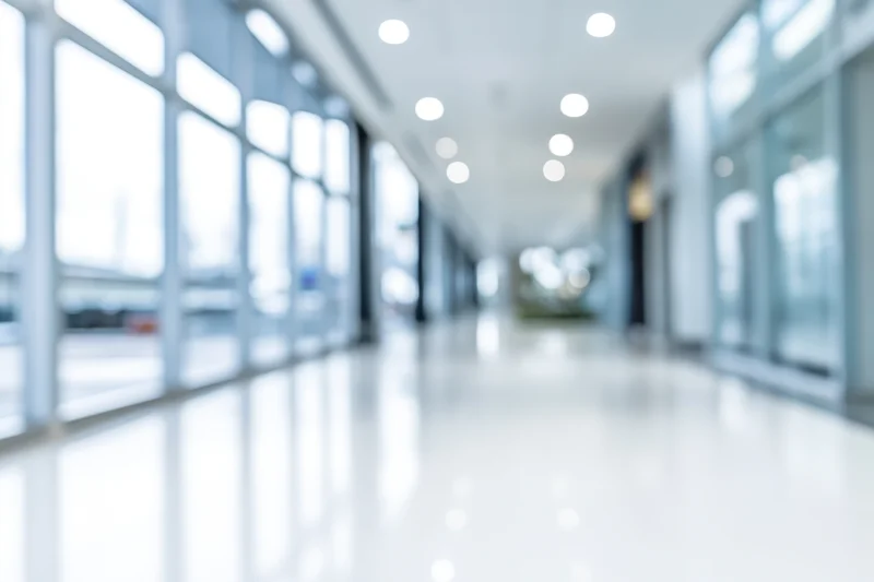 Bright empty modern lobby with floor-to-ceiling windows and polished white floor