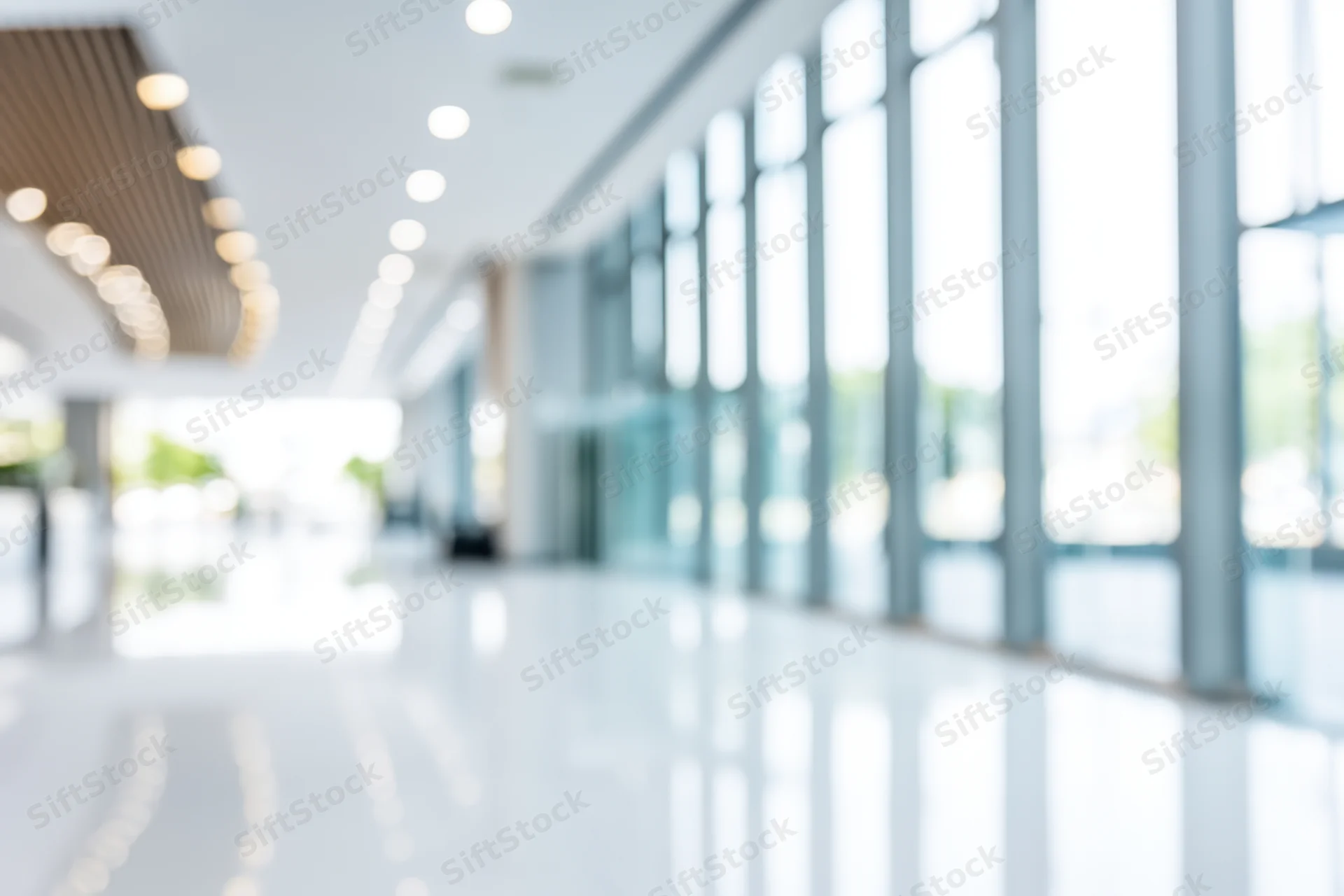 Bright empty modern lobby with floor-to-ceiling windows and polished white floor