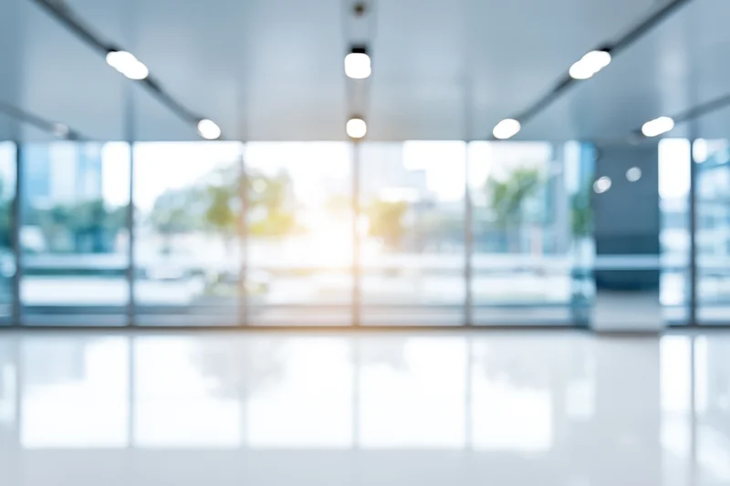 Bright empty modern lobby with floor-to-ceiling windows and polished white floor