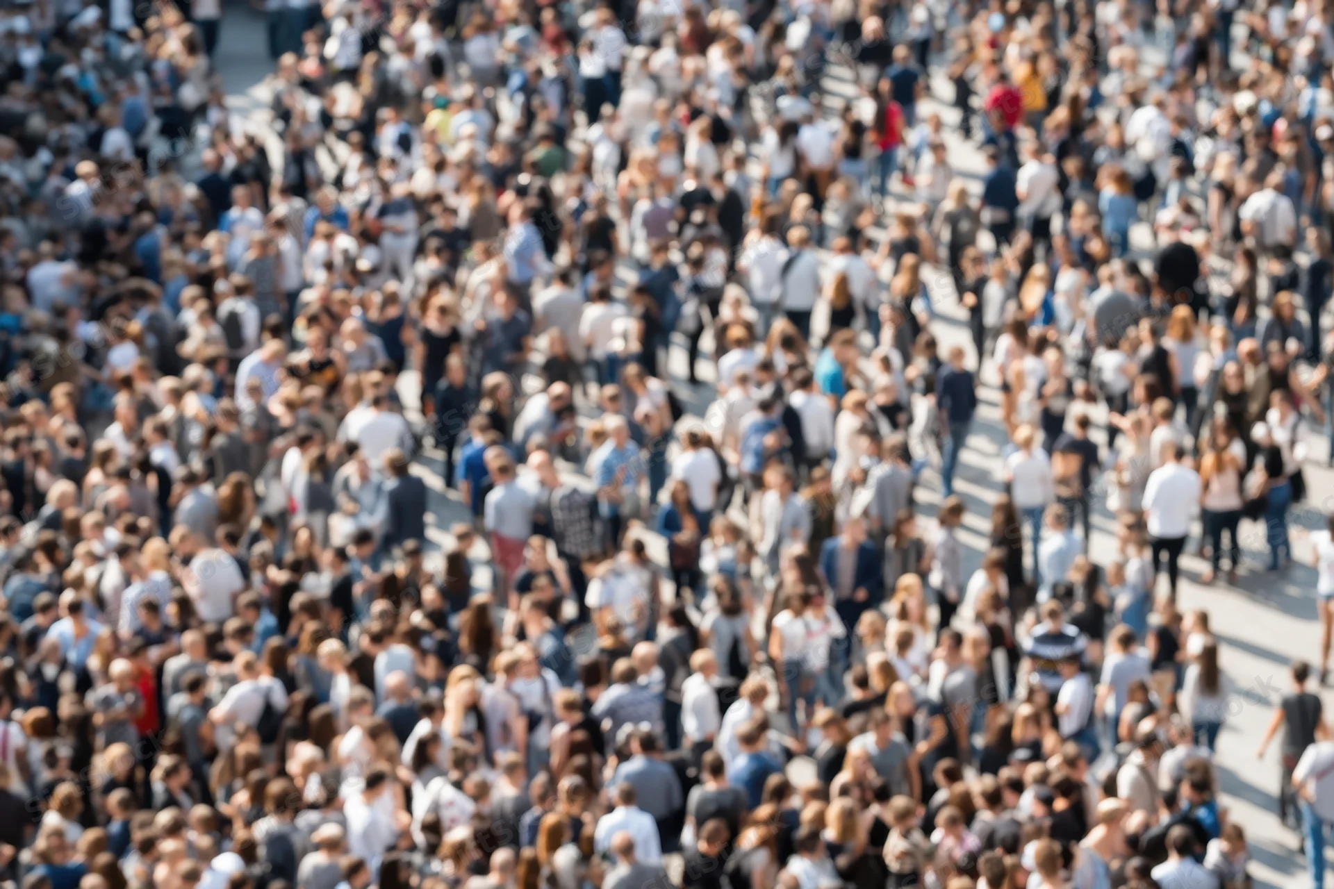 Dense crowd of people walking on city street viewed from above