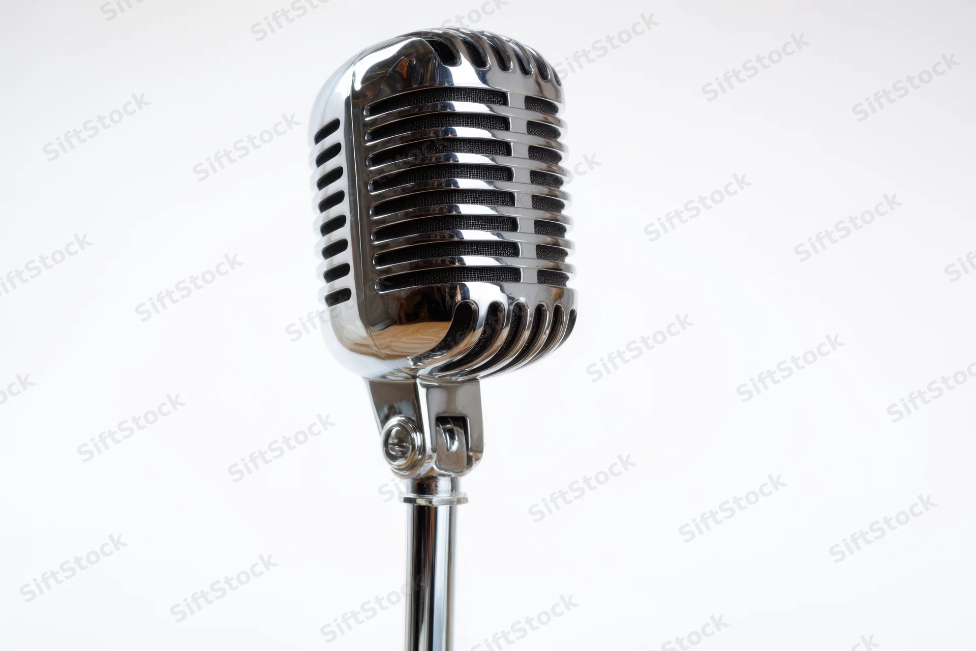 Vintage chrome microphone on a slim stand against a white background