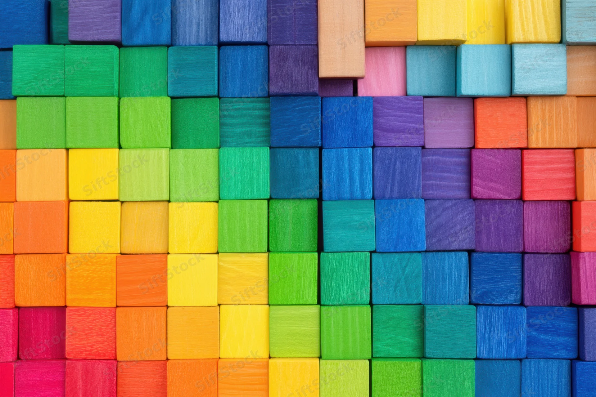Colorful wooden blocks arranged in a rainbow mosaic pattern