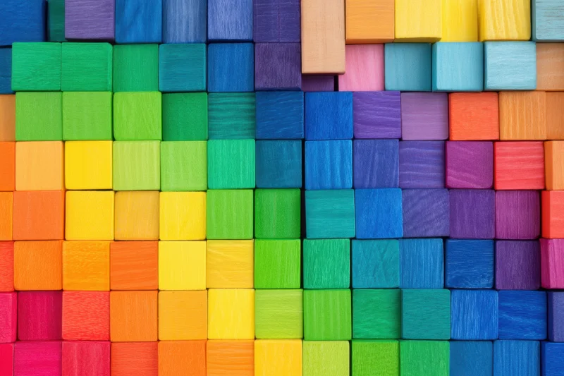 Colorful wooden blocks arranged in a rainbow mosaic pattern