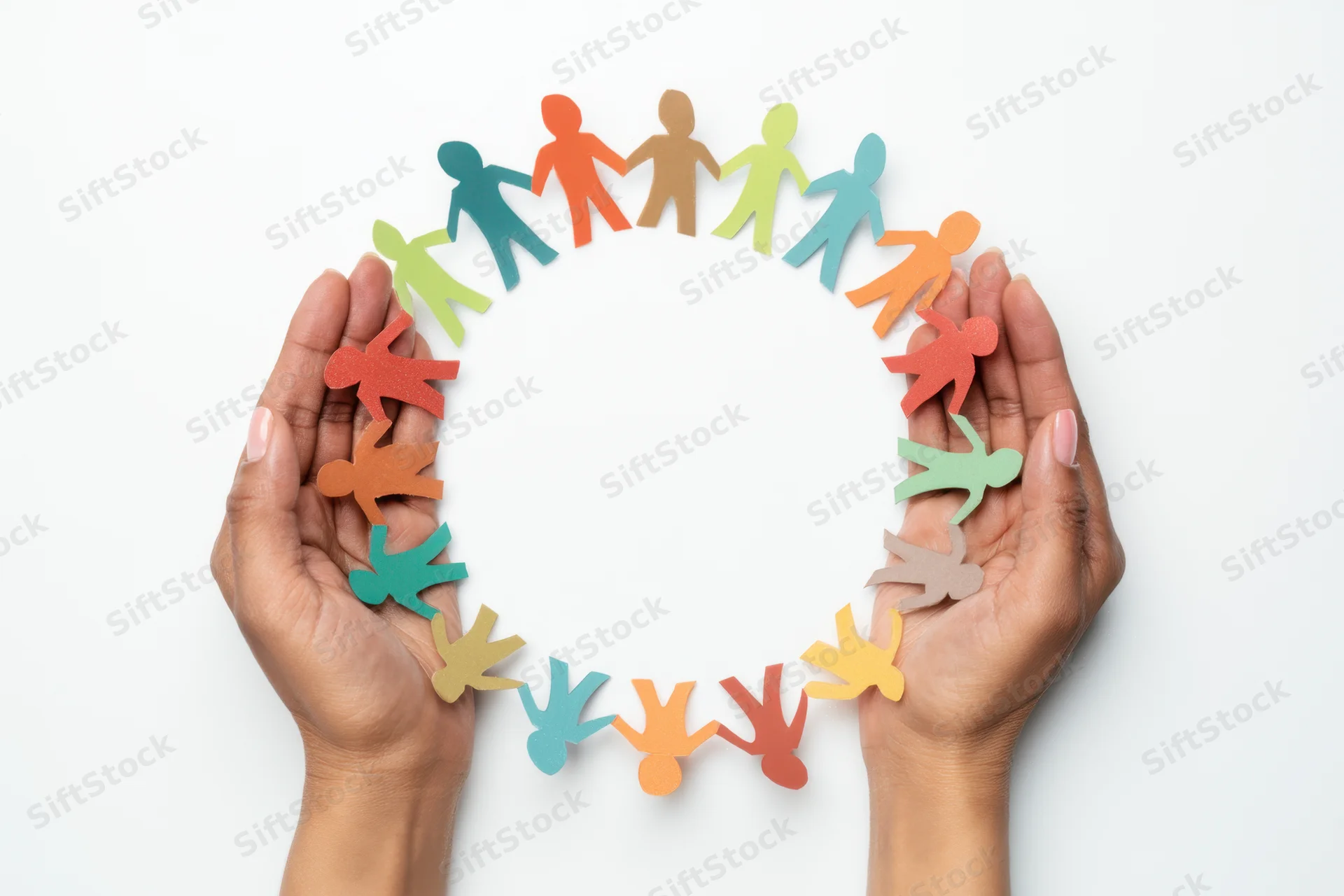 Hands cupping a circle of multicolored paper cut-out human figures