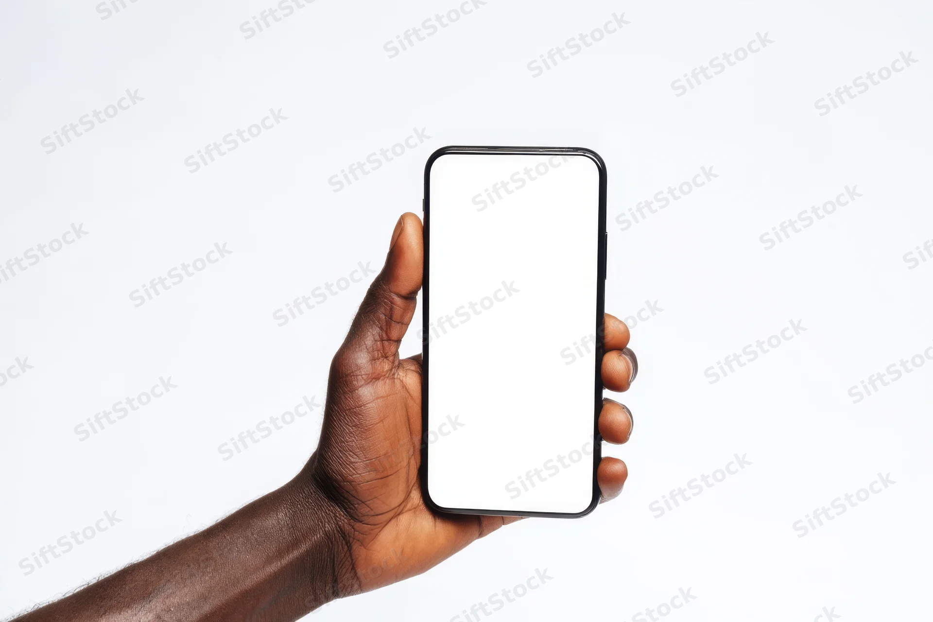 Dark-skinned hand holding a black-framed smartphone with blank white screen against white background