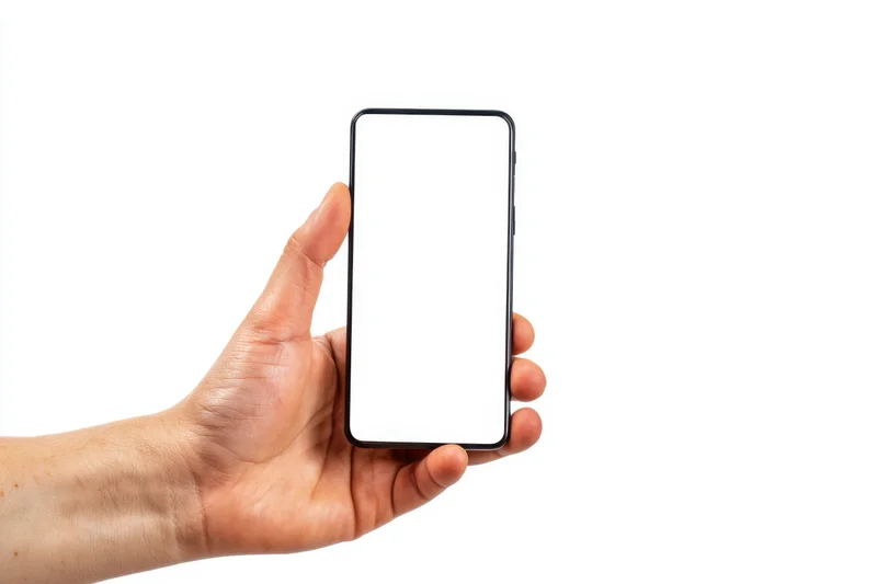 Hand holding a slim smartphone with blank white screen against white background