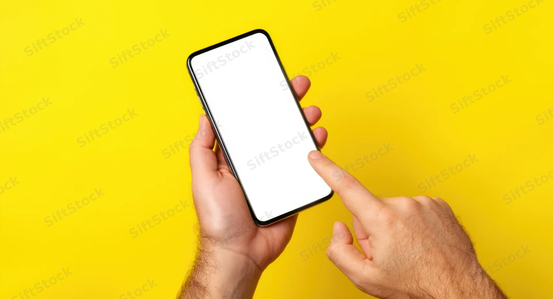 Hands holding smartphone with blank white screen against yellow background, finger pointing at display