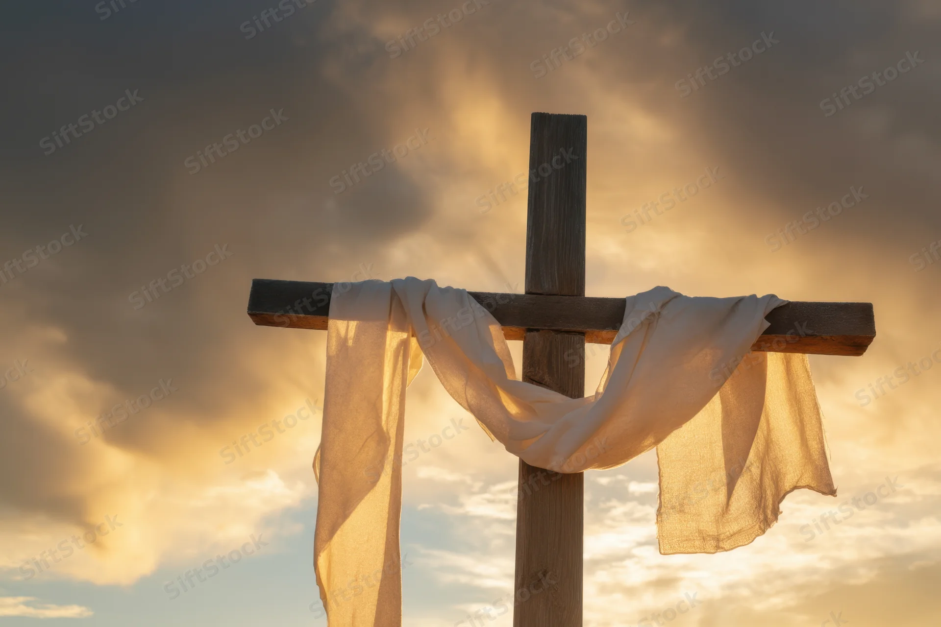 Weathered wooden cross with white fabric draped over it against a dramatic sunset sky