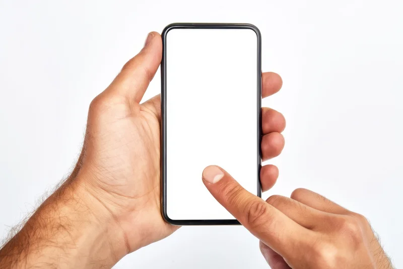 Hands holding smartphone with blank white screen, one finger touching display