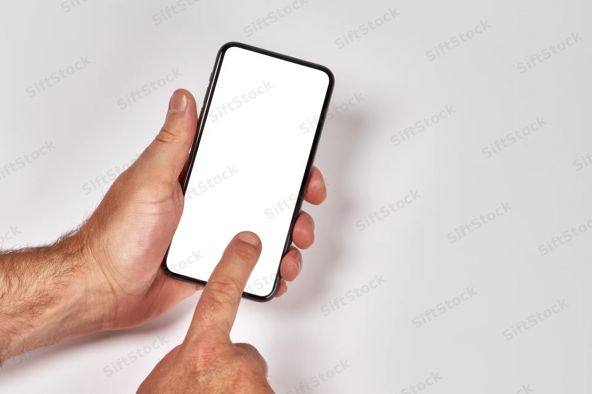 Hand holding smartphone with blank white screen, finger touching display, isolated on white background