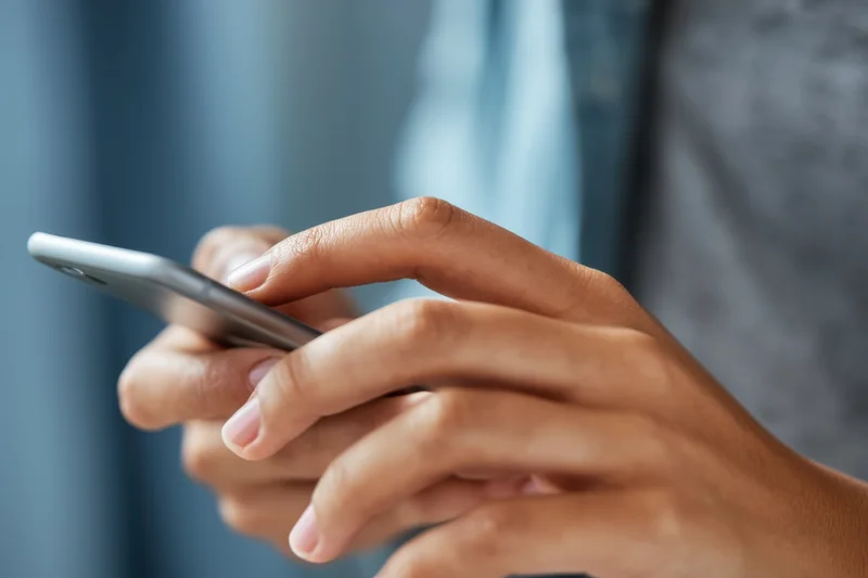 Closeup of hands tapping on a smartphone screen