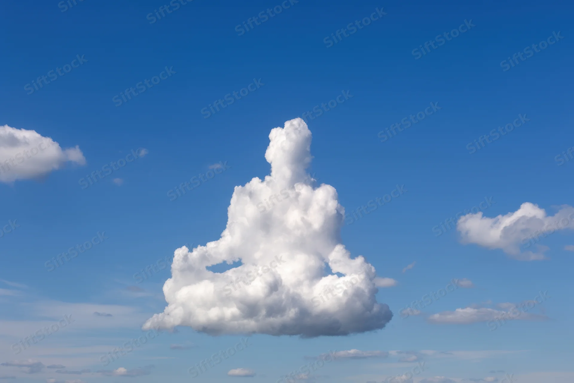 Large fluffy cloud shaped like a meditating figure floating in a clear blue sky