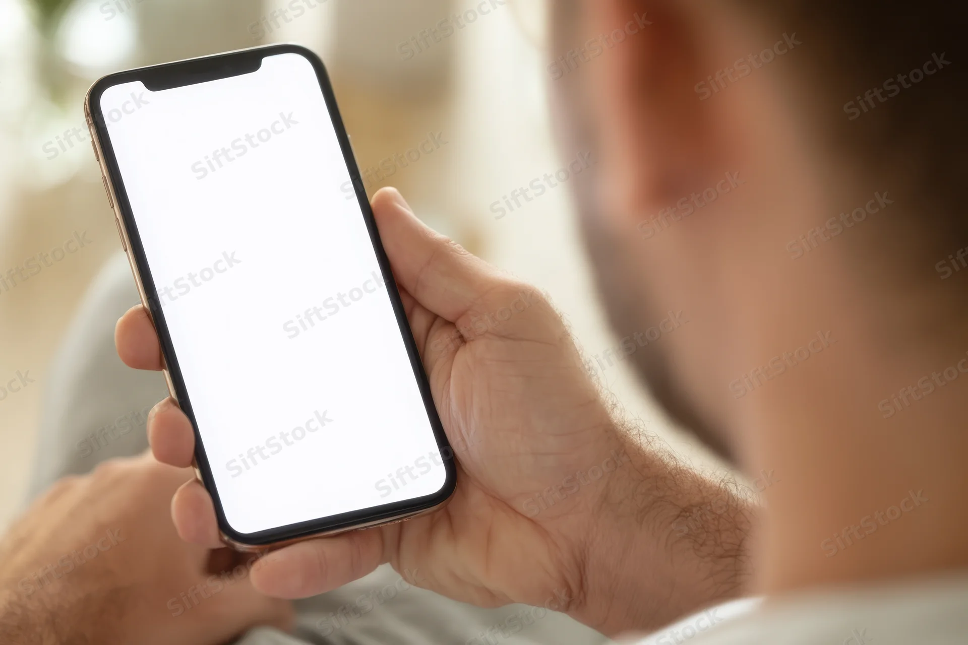 Man holding smartphone with blank white screen in closeup view