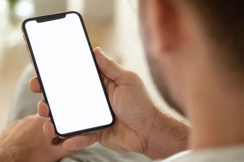 Man holding smartphone with blank white screen in closeup view