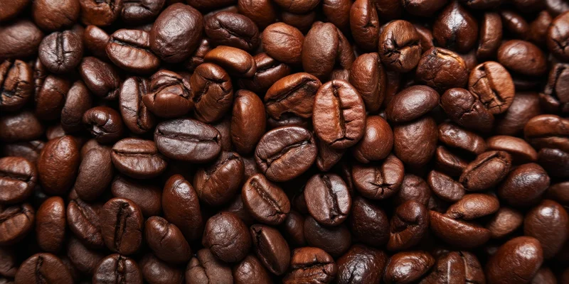 Close-up of roasted coffee beans densely packed showing texture and rich brown color