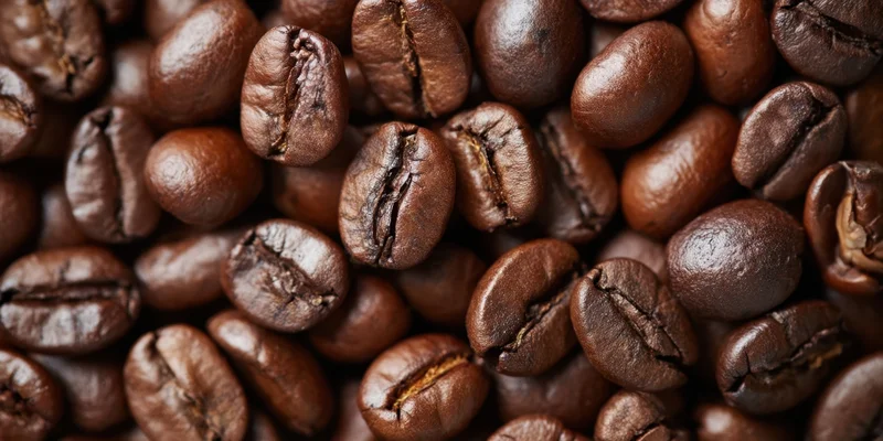 Close-up of roasted coffee beans densely packed on a flat surface