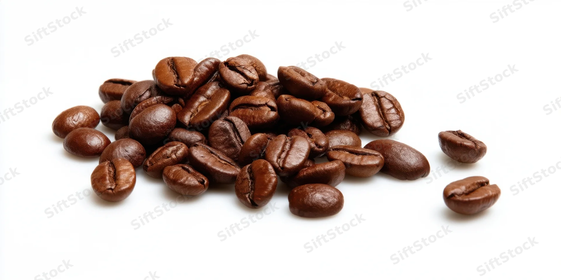 Roasted coffee beans scattered in a pile on a white background