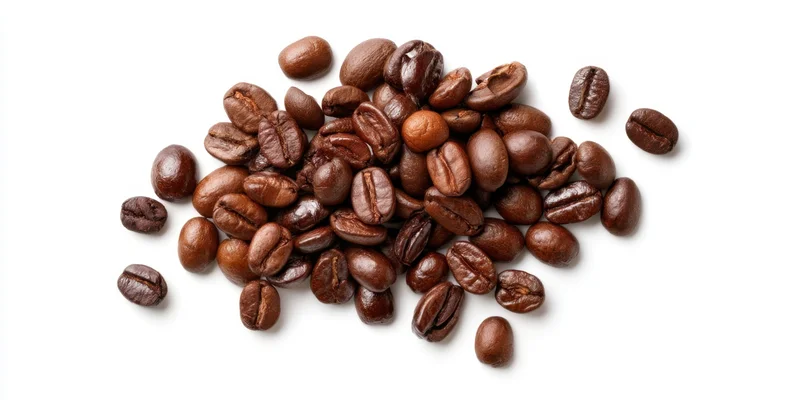 Roasted coffee beans scattered in a pile on a white background