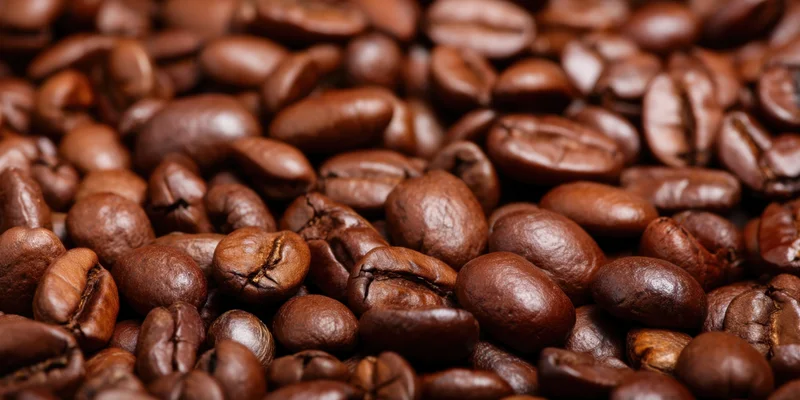 Close-up of glossy roasted coffee beans densely piled together