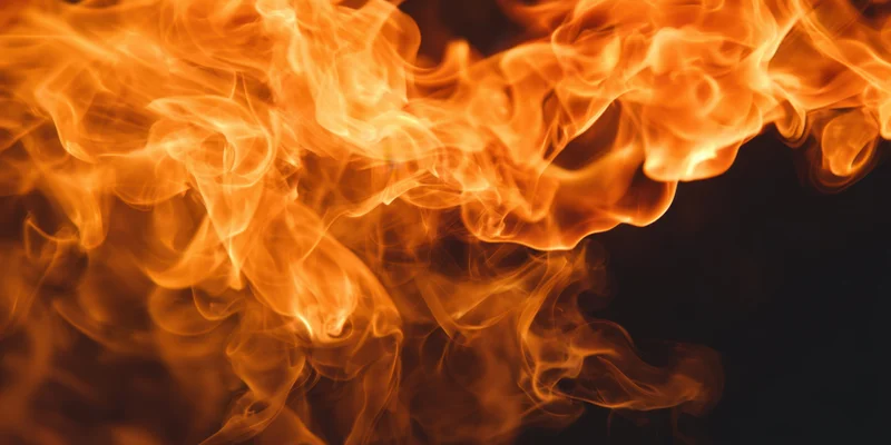 Swirling orange and amber flames against a dark background