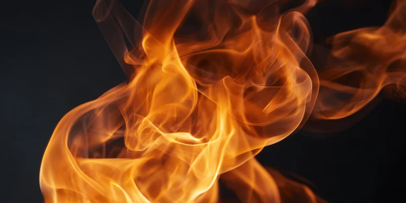 Swirling orange and amber flames rising against a dark background