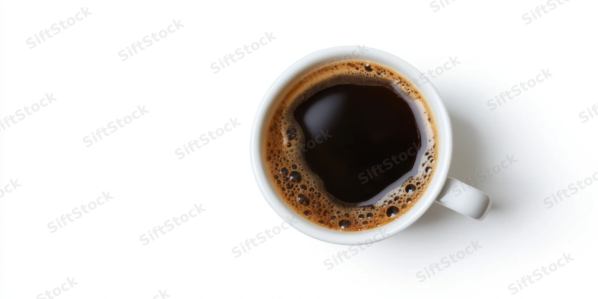 Top-down view of a white ceramic cup filled with dark coffee on a plain white surface