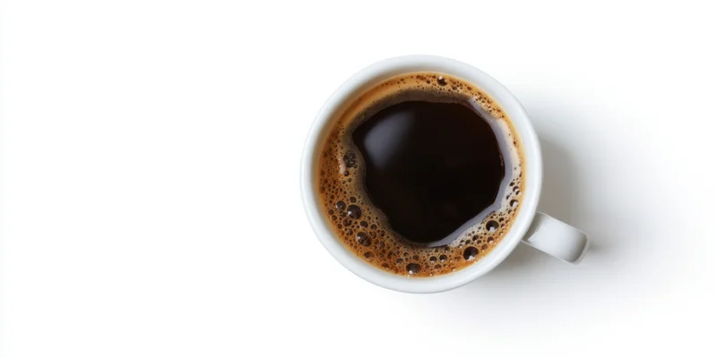 Top-down view of a white ceramic cup filled with dark coffee on a plain white surface