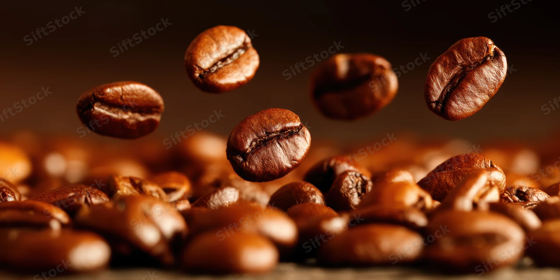 Roasted coffee beans falling in midair over a pile with shallow focus