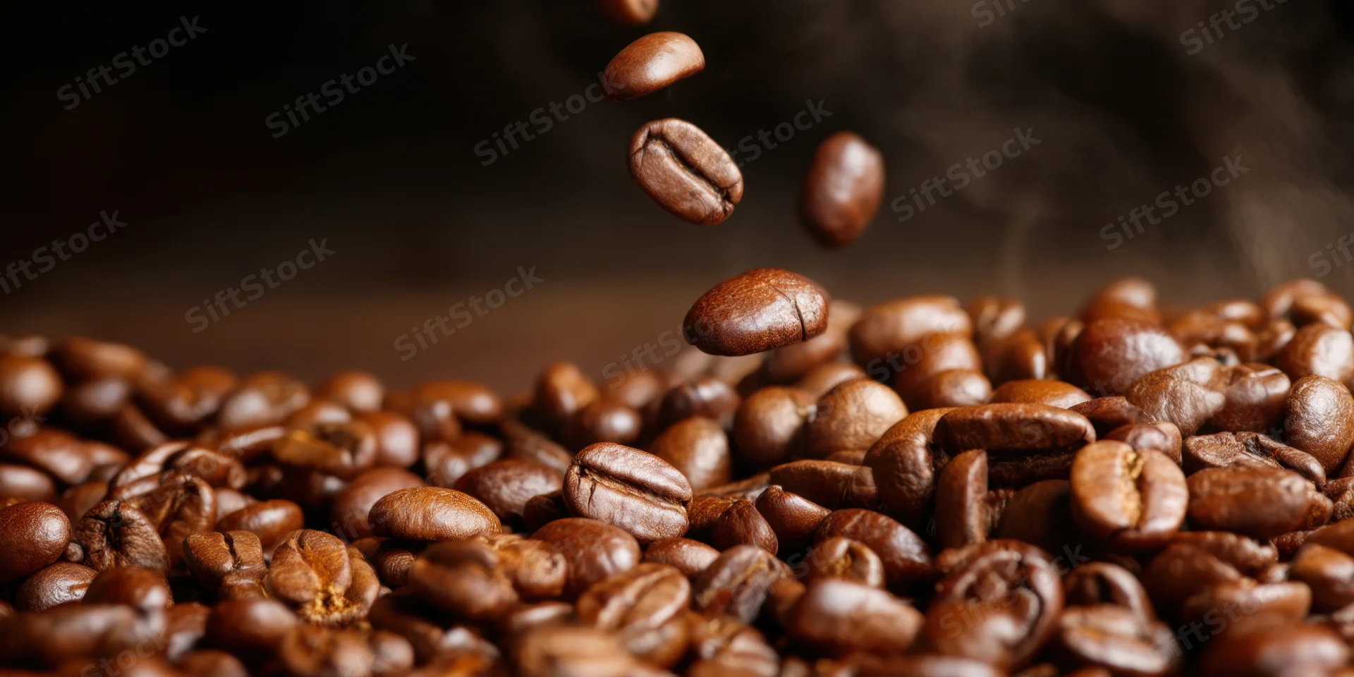 Roasted coffee beans falling into a pile with steam rising, close-up view