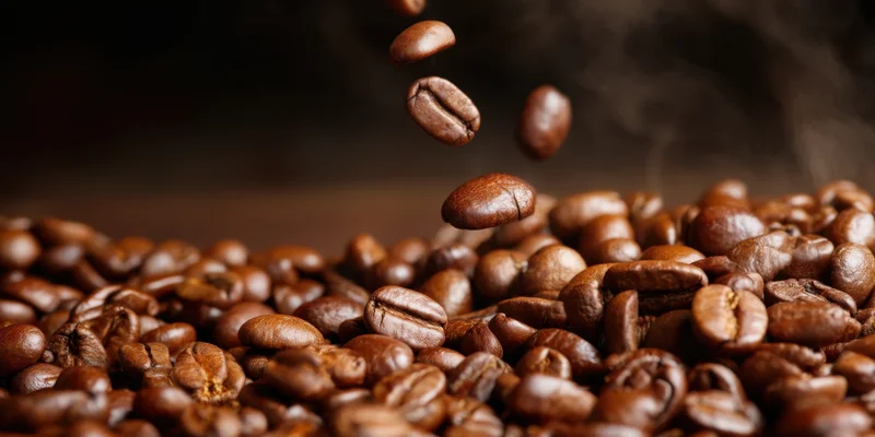 Close-up of roasted coffee beans with a few beans suspended
