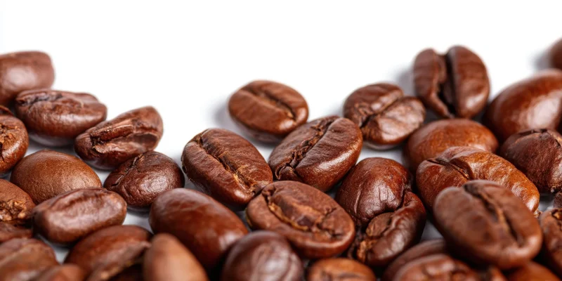 Roasted coffee beans scattered on a white background