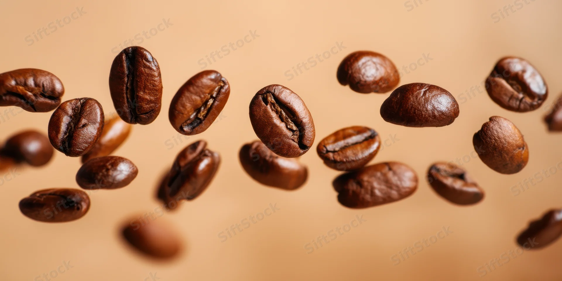Roasted coffee beans floating in midair above a warm beige background
