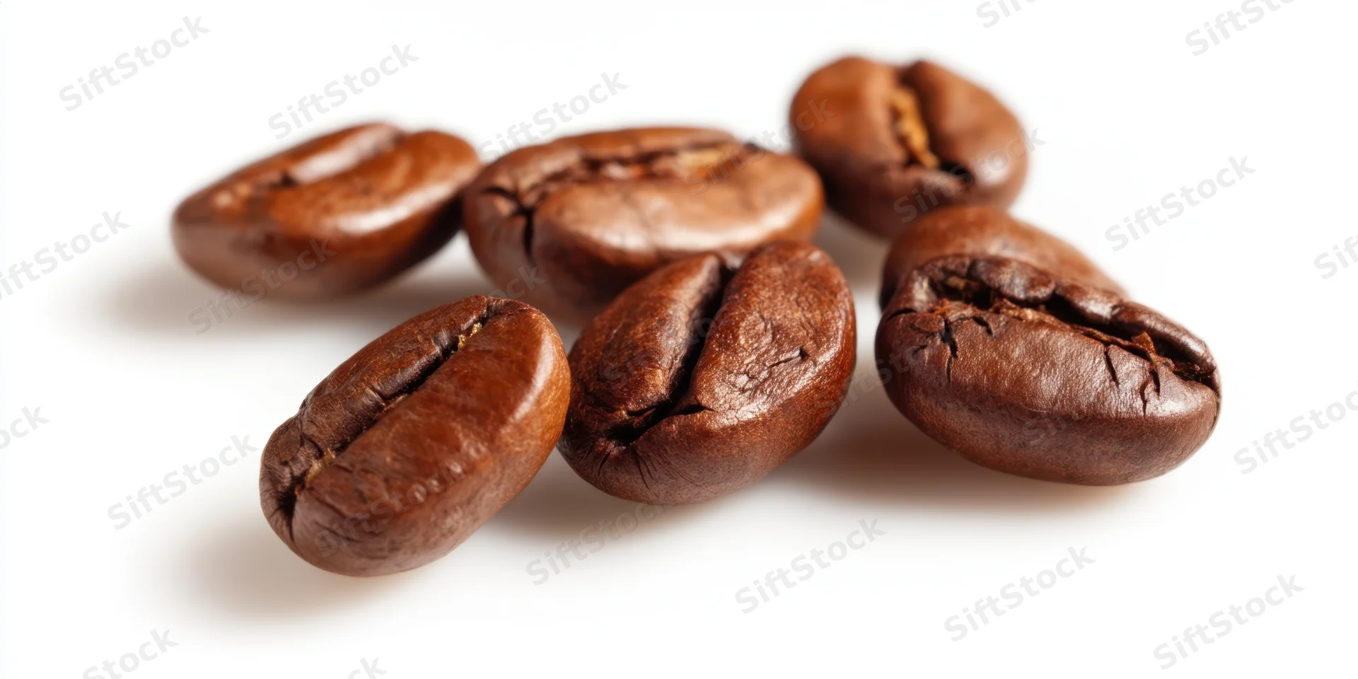 Roasted coffee beans arranged on a white surface