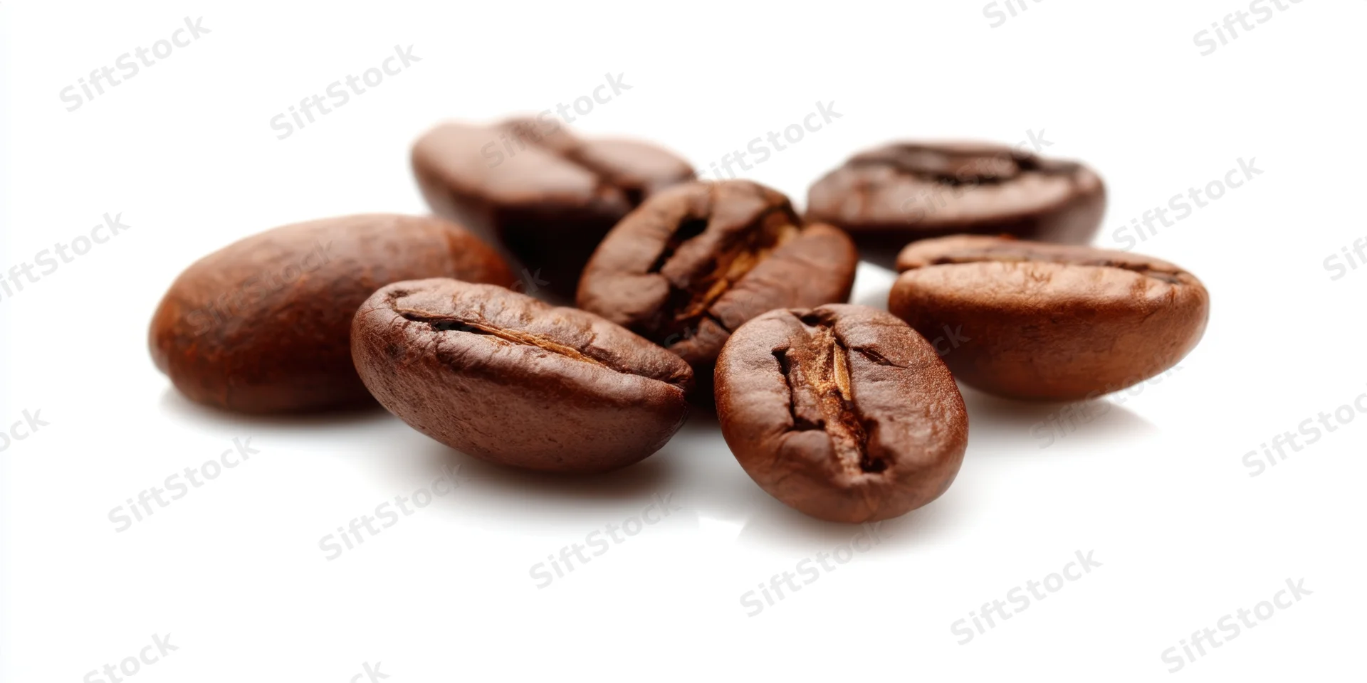 Roasted coffee beans arranged in a small cluster on a white surface