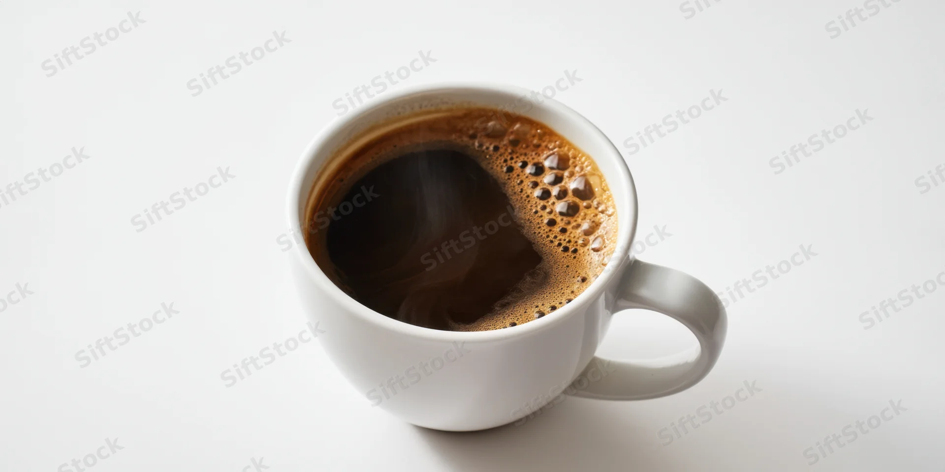 White ceramic mug filled with steaming dark coffee and crema on plain white surface