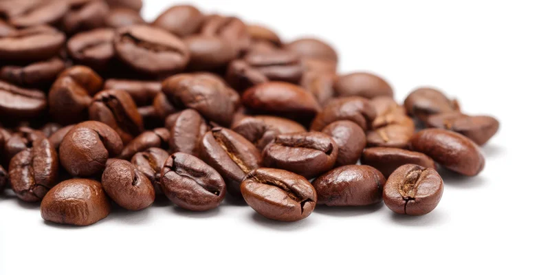 Roasted coffee beans scattered on a white background